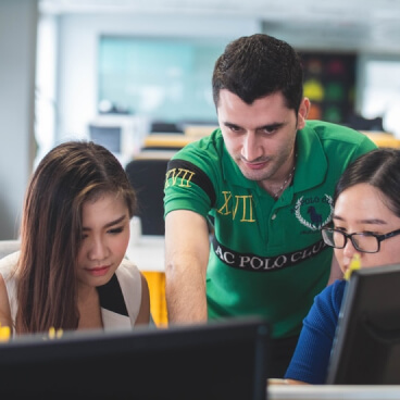 Man is discussing with women in computer lab 